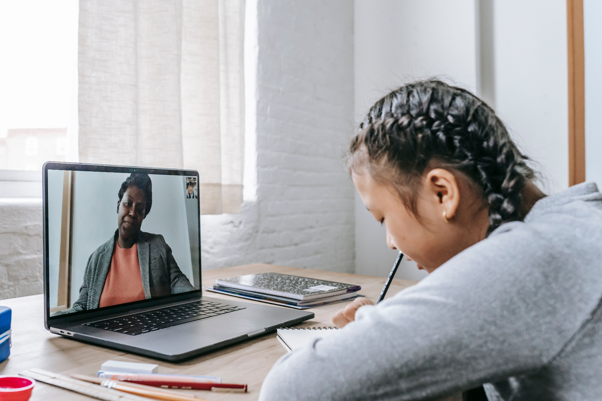 Student taking notes during an online tutoring session